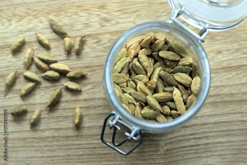 Cardamom in jar. Shot from top, Close up with selective focus. Dried pods of green Cardomom pods is an expensive spice used in Indian subcontinent food and drinks for fragrance and unique flavor. photo