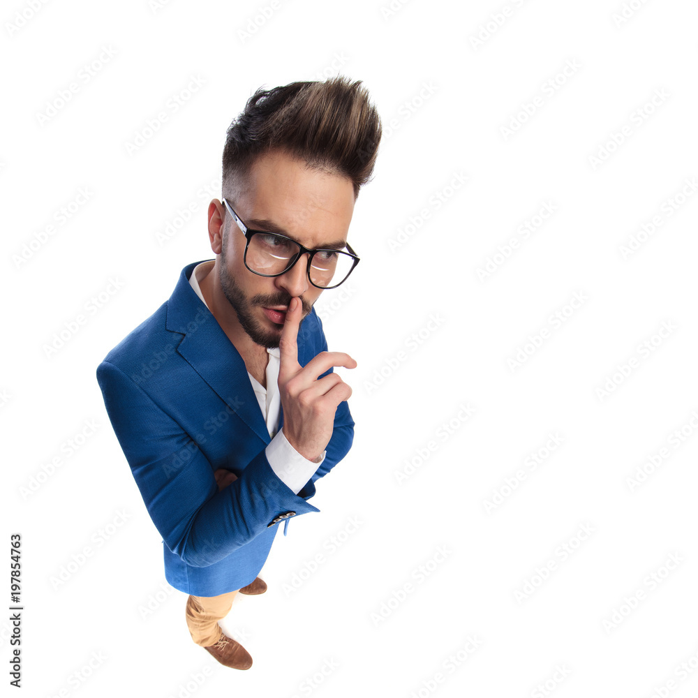attractive smart casual man making the shush sign to side attractive smart casual man making the shush sign to side