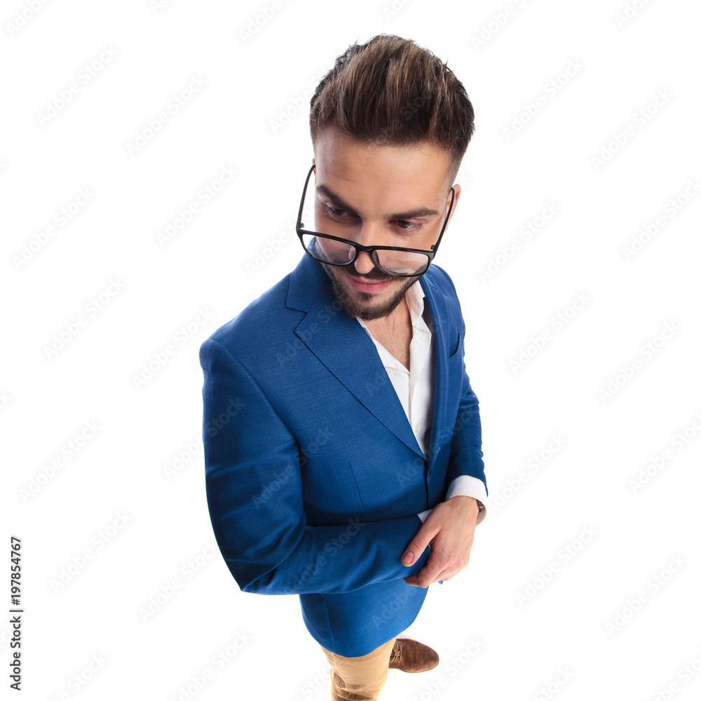 casual man with hands folded looks over glasses to side casual man with hands folded looks over glasses to side