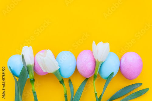 Easter eggs and spring flowers on yellow background © EkaterinaVladimirova