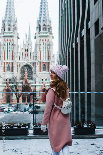 Tourist life. Full length rear view of young woman in pink coat looking away while standing outdoors. © MARIIA