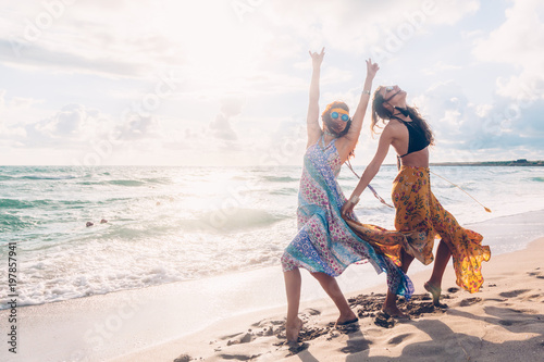 Boho girls walking on the beach