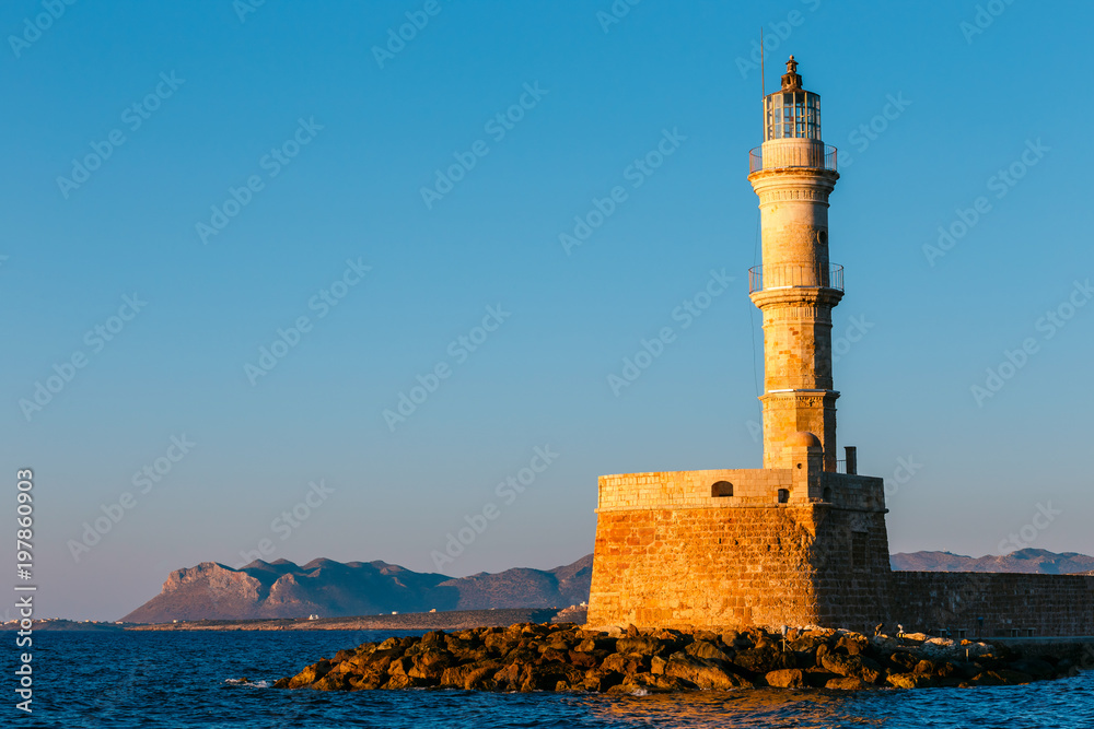 view of the entrance to Chania harbor with lighthouse at sunset, Crete, Greece view of the entrance to Chania harbor with lighthouse at sunset, Crete, Greece