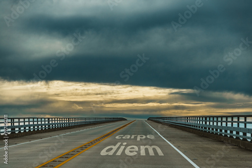 carpe diem - confidence - dark clouds hang low over a highway photo