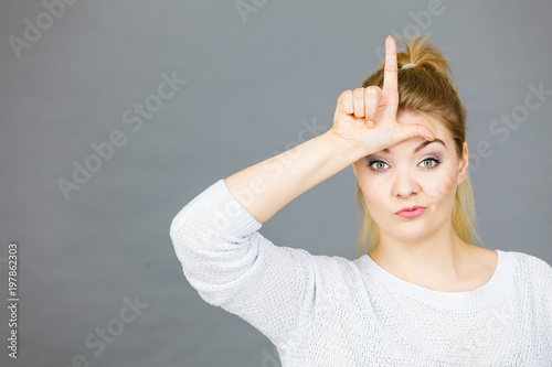 Fotografía Woman showing loser gesture with L on forehead