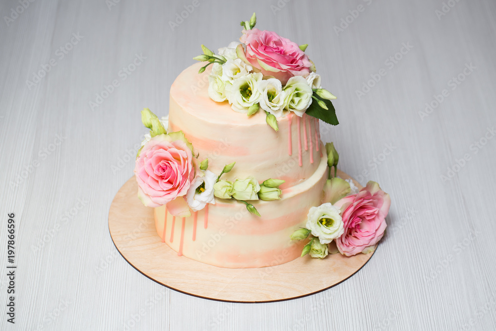Tiered cake with fresh flowers and macaroons Tiered cake with fresh flowers and macaroons