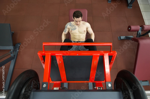 Attractive Young Man Doing Leg Press On Machine In Gym. © Artem Zakharov