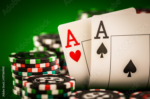 Obraz na plátně Stack of chips and two aces on the table on the green baize
