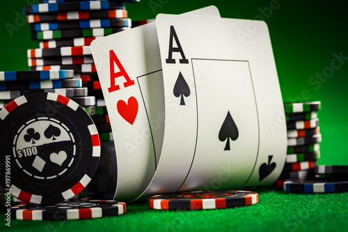 Fotografie Stack of chips and two aces on the table on the green baize