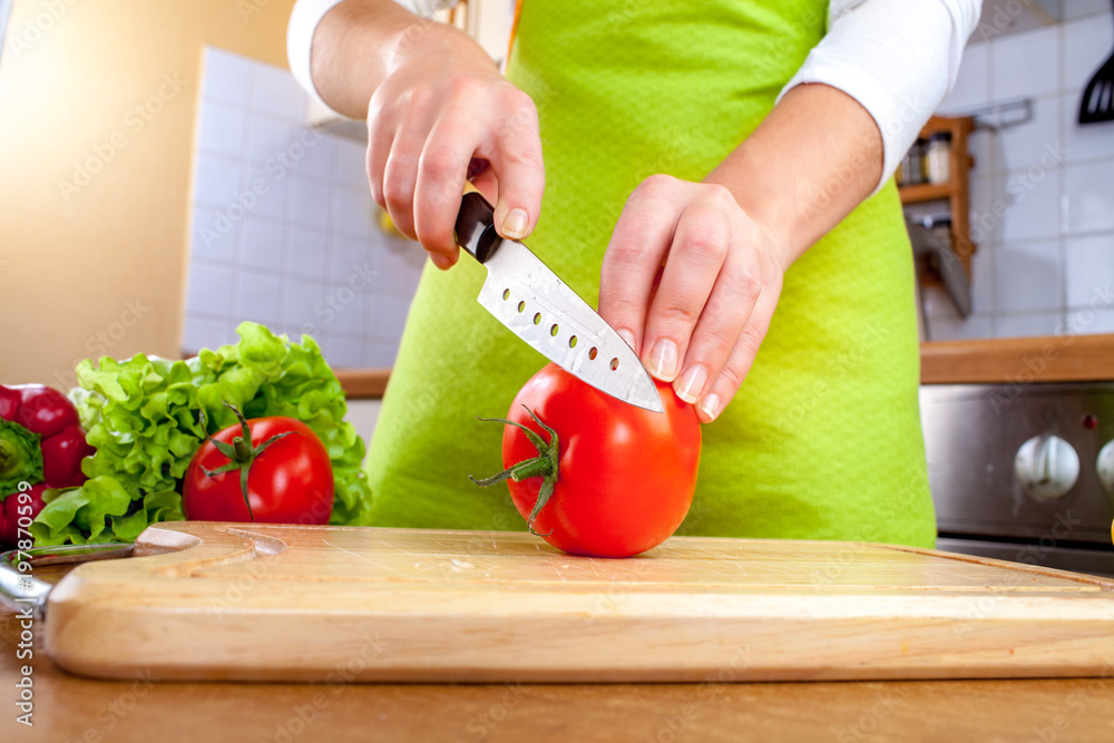 Woman's hands cutting tomato Woman's hands cutting tomato