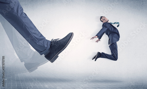 Businessman big foot kicking small, young businessman who is flying
