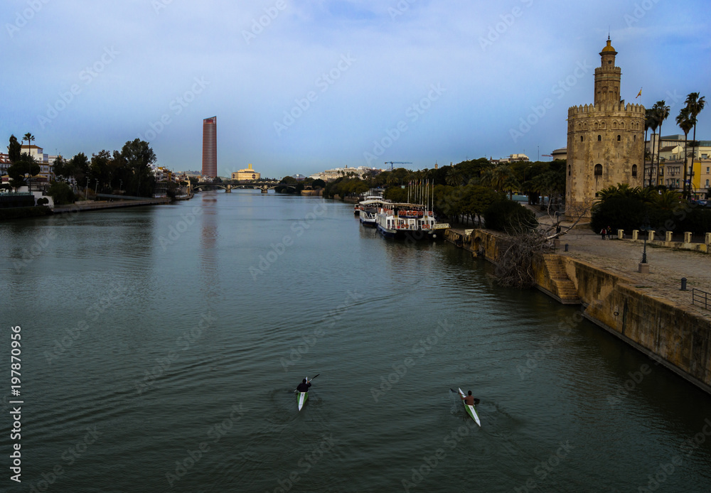 Obraz premium View of Golden Tower (Torre del Oro), Seville Tower and Guadalquivir river with canoeists. February 2018, Seville, Andalusia, Spain.