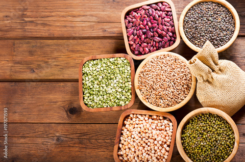 various cereals, seeds, beans and grains on wooden table