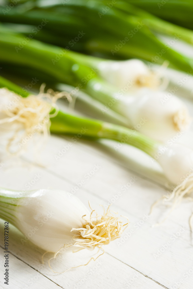 Spring onions on white wooden table