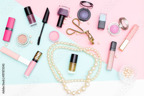 Decorative cosmetics and pearls on a pink background. flat lay