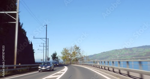  C4k driving view through  a on highway 8, and countryside nature, finaly revealing the turquoise thunersee lake, in berner oberland, on a sunny autumn day, in the swiss alps of Switzerland photo