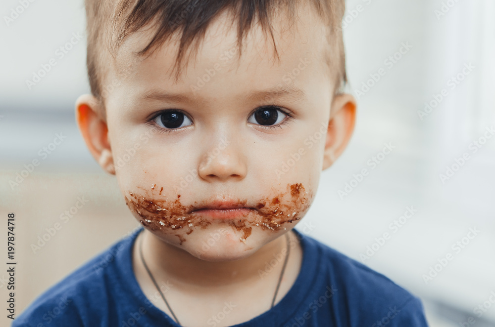 Charming child portrait, dirty face in chocolate or condensed milk Charming child portrait, dirty face in chocolate or condensed milk