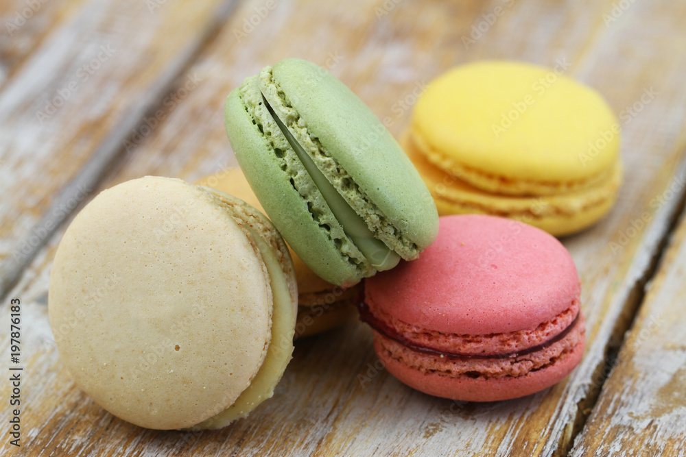 Fototapeta premium Close up of pistachio, raspberry, lemon and vanilla macaroons on wooden surface