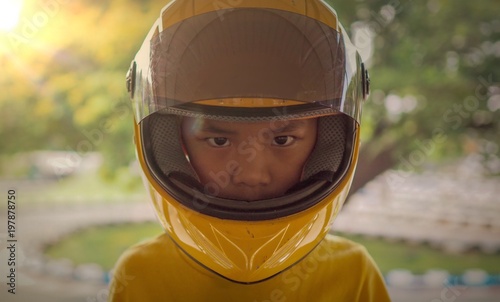 Closeup of Asian boy face wearing a yellow motorcycle helmet. © Mr. Note19