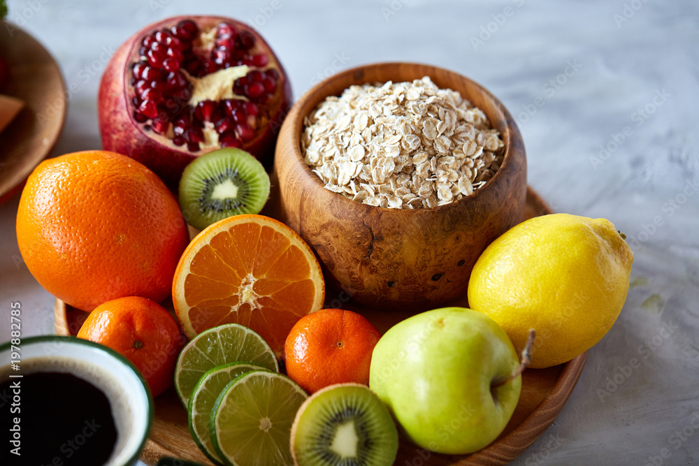 Bowl with oatmeal flakes served with fruits on wooden tray over rustic background, flat lay, selective focus Bowl with oatmeal flakes served with fruits on wooden tray over rustic background, flat lay, selective focus