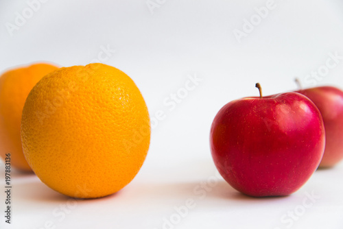 Red apple and orange on a white background.