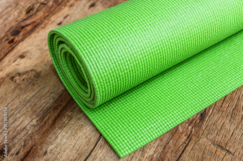 yoga mat green color on wooden background