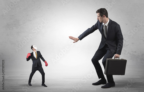 Big businessman being afraid of small masked businessman with box gloves in an empty room concept 