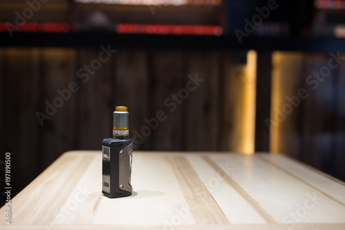 vape stands on a wooden table. Accessory store for vape