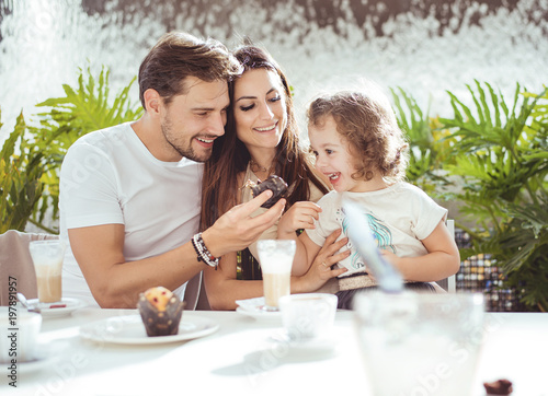 Cheerful parents feeding their daughter