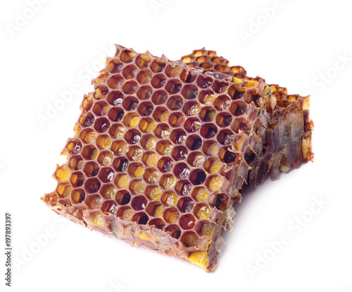 Bee bread granules and a piece of honey cells are isolated on a white background. Natural remedy for immunity enhancement. Beekeeping products. Apitherapy. photo