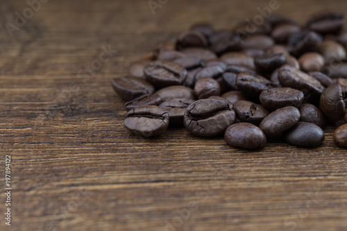 Texture of coffee beans on a wooden background close-up.