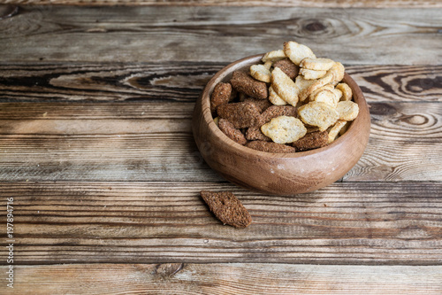 Rye and wheat crumbs in a bowl. A snack for beer on a wooden table.