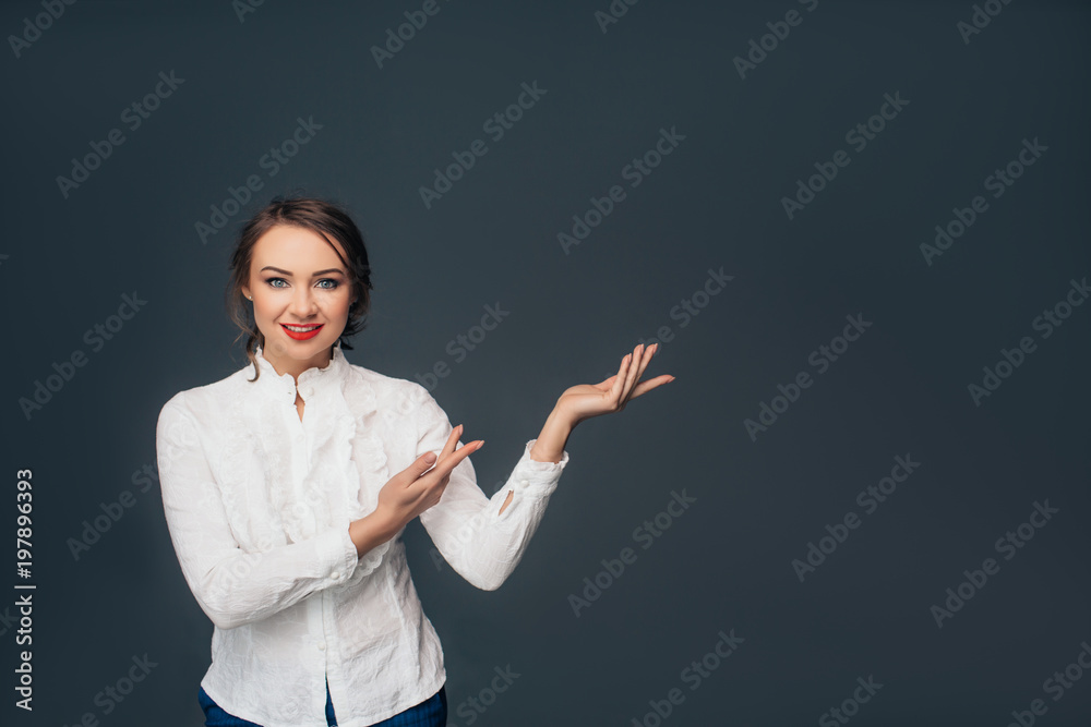 Look over there. successful young woman, pointing copy space and looking at camera while standing against grey background Look over there. successful young woman, pointing copy space and looking at camera while standing against grey background