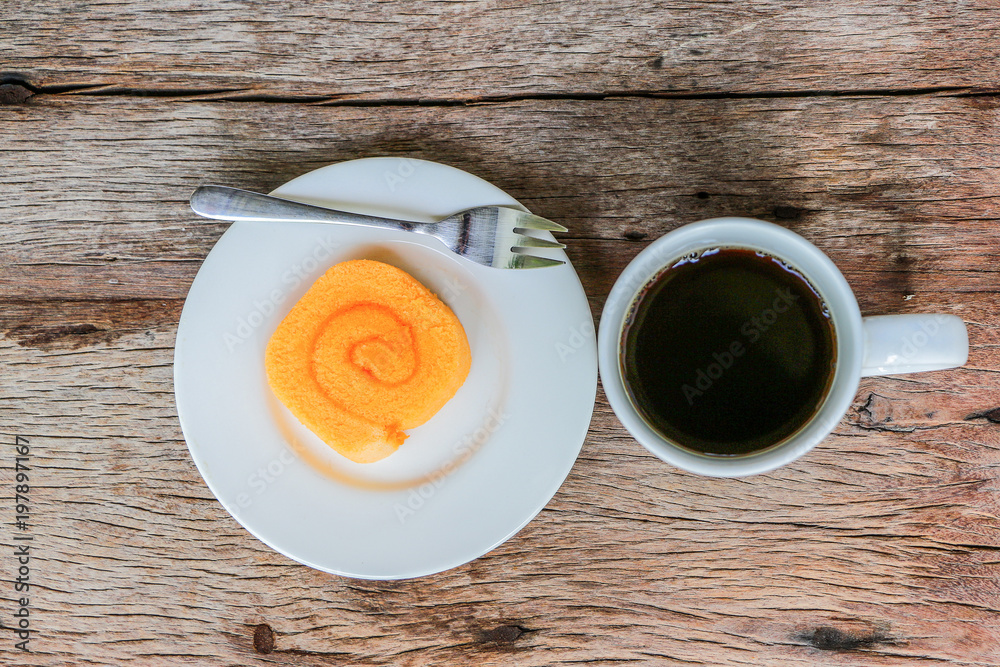 Orange Jam Roll Cake With Black Hotel Cofee on Wooden Table Orange Jam Roll Cake With Black Hotel Cofee on Wooden Table