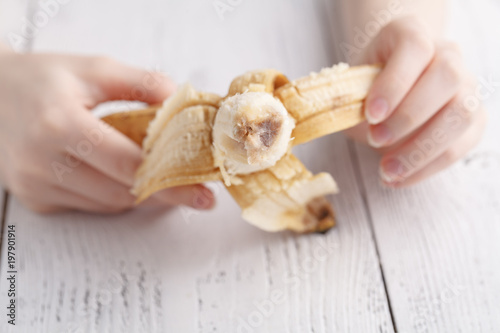 Opening banana in female hands