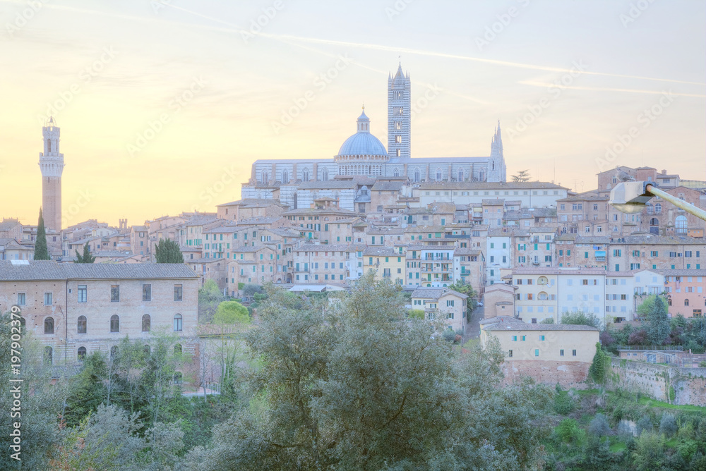 Beautiful panoramic view of the medieval old town of Siena at sunrise with Mangia Tower, Duomo Dome and Bell Tower ~ A UNESCO world heritage city in northern Italy ( faded color effect )