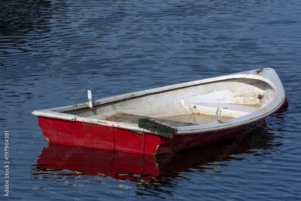 A small fiberglass row boat slowly sinking into Loch Lomond A small fiberglass row boat slowly sinking into Loch Lomond