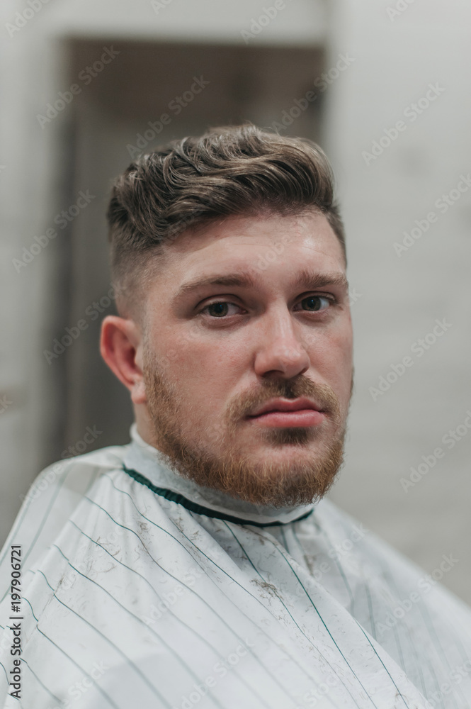 Obraz premium A man in a barber shop for haircuts and shaving