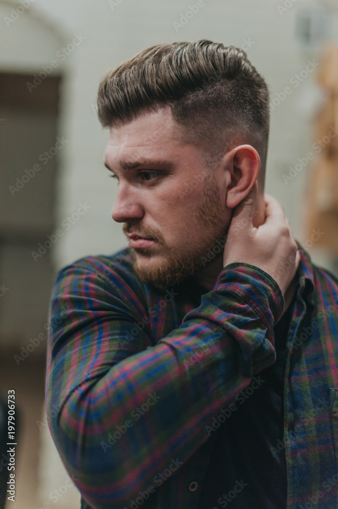 Obraz premium A man in a barber shop for haircuts and shaving