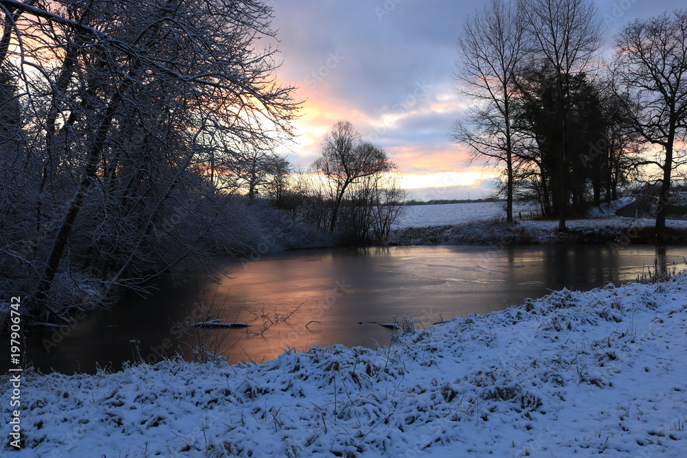Fototapeta premium Un coucher de soleil au bord d'un étang