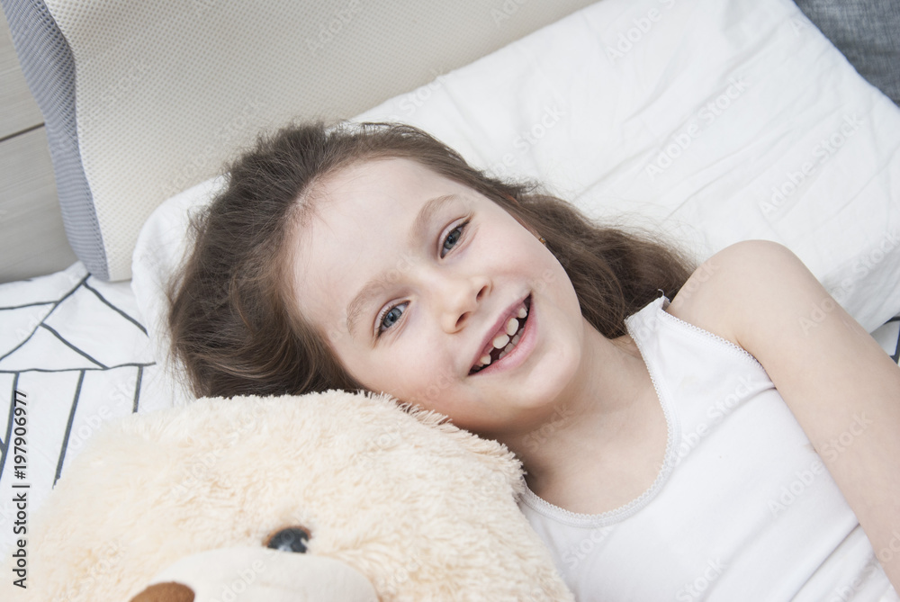 Cute Smiling Little Girl Woke up in White Bed. Morning in Wekeend. Flat Lay. Top view. Sleeping children. Cute Smiling Little Girl Woke up in White Bed. Morning in Wekeend. Flat Lay. Top view. Sleeping children.