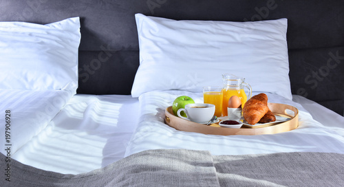 Breakfast on tray in bed in hotel room