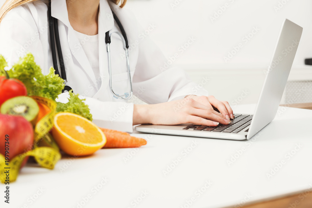 Female nutritionist working on laptop Female nutritionist working on laptop