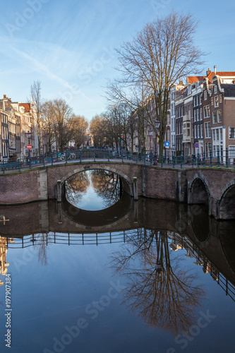 Fototapeta Naklejka Na Ścianę i Meble -  water canals in Amsterdam with a bridge in the middle and traditional architecture