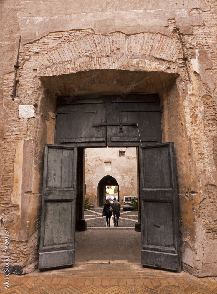 Naklejka premium Die Basilica dei Santi Quattro Coronati in Rom mit ihren zwei Innenhöfen. Hier das Tor, eine Verbindung zwischen den beiden Innenhöfen.
