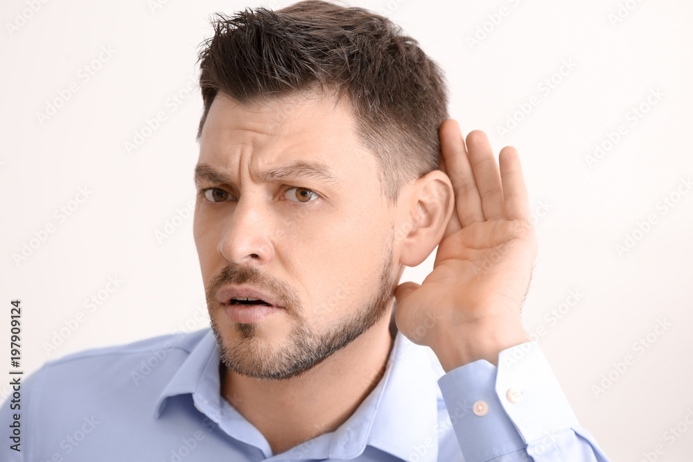 Obraz premium Mature man with hearing problem on light background