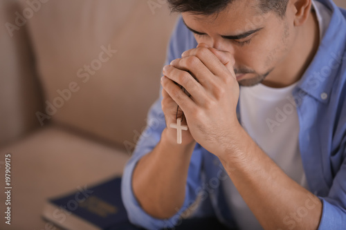 Εκτύπωση καμβά Religious young man praying to God at home