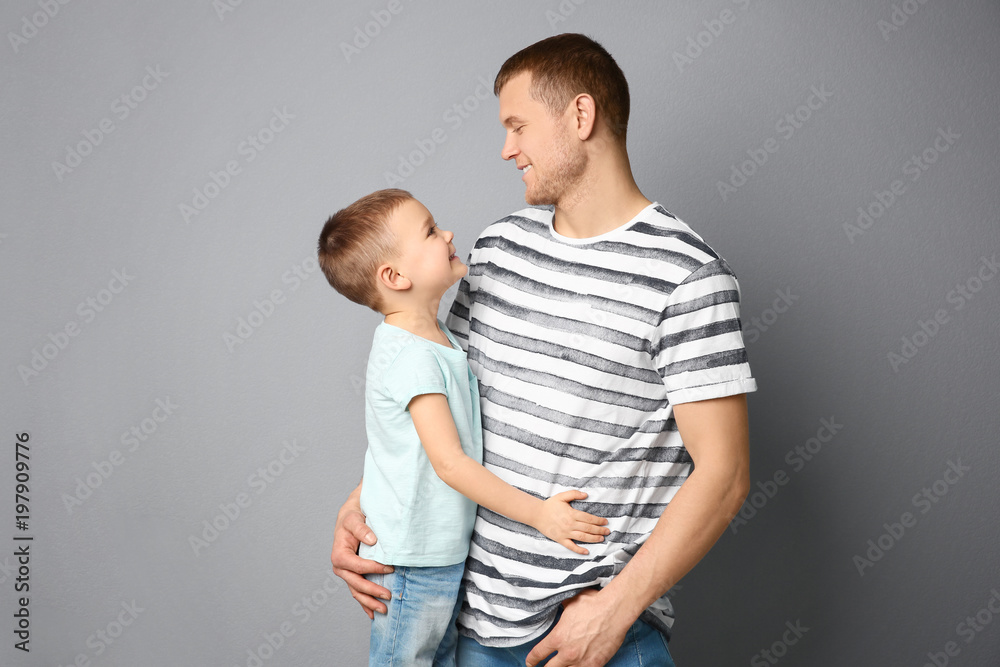 Dad and his son hugging on grey background. Father's day celebration Dad and his son hugging on grey background. Father's day celebration