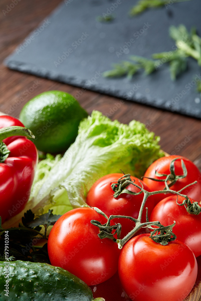 Close-up still life of assorted fresh vegetables and herbs on wooden rustic background, top view, selective focus.