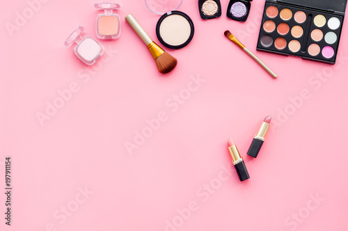 Women desk with decorative cosmetics for make up on pink background flat lay space for text